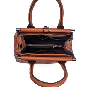 Detail view of large brown woven handbag showing multi-pocket interior and zip compartment