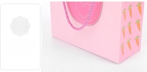 Détail du sac cadeau en papier rose avec motif carotte et coutures de fond renforcées