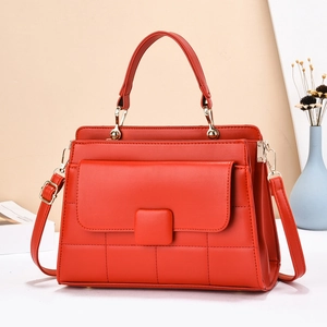 Gros plan du sac à main matelassé rouge vif avec détails dorés et boucle carrée