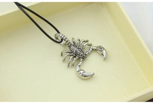 Detailed macro shot of a silver scorpion pendant with vintage punk rock aesthetic