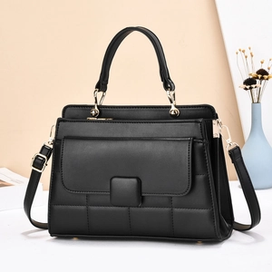 Détail d'un sac à main noir avec garnitures dorées et texture matelassée élégante