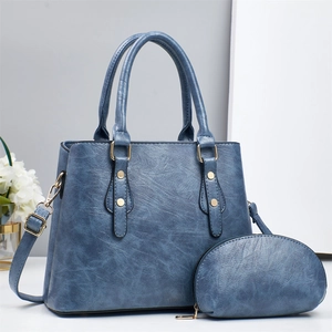 Detail view of navy blue faux leather tote bag with gold hardware and coin purse