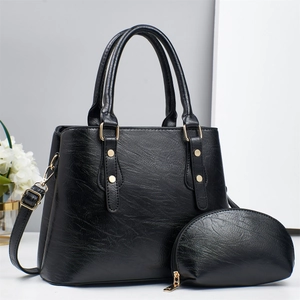 Detailed view of black faux leather tote set with matching pouch and gold hardware