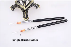 Detail of two nail art brushes with black handles, orange bristles and protective caps
