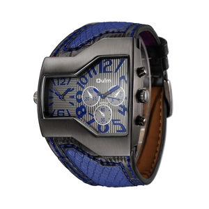 Detailed close-up of a tonneau-shaped dual time watch with blue indexes and snake skin strap