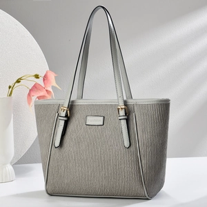 Détail du grand sac cabas gris plissé avec textures verticales et boucles dorées