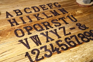 Lettere e numeri in ghisa retrò A-Z 0-9 per targhe fai-da-te su sfondo di legno rustico