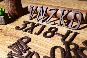 Primo piano di lettere e numeri vintage in ghisa esposti su una superficie di legno rustico