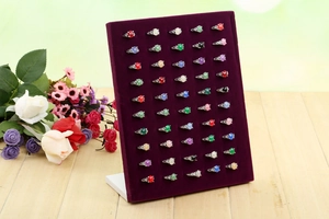 Deep purple velvet 50-slot ring display stand shown on a light wood surface