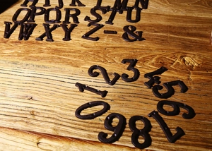 Primo piano di lettere e numeri in ghisa vintage su uno sfondo di legno rustico
