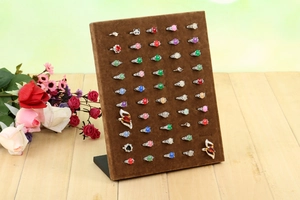 Brown velvet L-shaped jewelry organizer stand displaying 50 rings on wooden surface