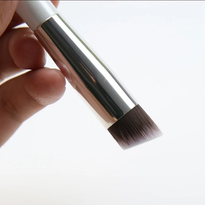 Close-up of slanted foundation brush with brown gradient bristles and white handle