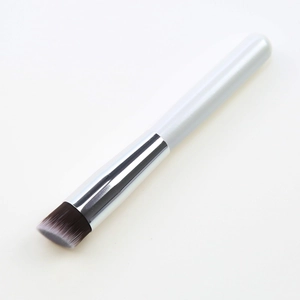 Detailed view of single makeup brush with white handle and gradient brown bristles