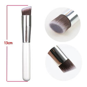 Flat angled foundation brush with synthetic bristles and white handle for makeup application