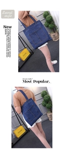 Detail view of large denim canvas tote bag with dual front pockets and shoulder straps