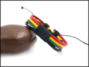 Detail of multi-layered braided leather bracelet with red, yellow, and green reggae cords