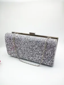 Close-up of silver sequin evening clutch bag with metal chain and hard shell closure