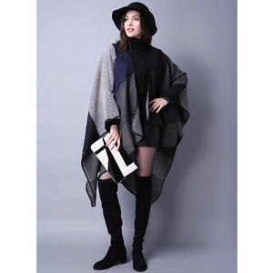 Detail shot of a women's knitted color-block poncho with grey and navy panels