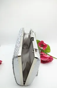 Detail of silver sequin evening clutch with metal frame and gray satin lining