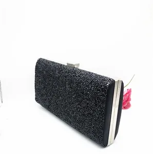 Detail shot of black rhinestone evening clutch bag with silver metal frame and clasp