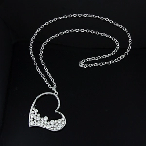 Dettaglio ravvicinato di una grande collana con ciondolo a cuore argento e cristalli lucidi