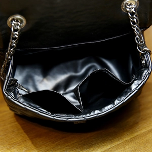 Black quilted mini chain bag with double interior pockets shown from an overhead perspective