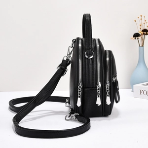 Detailed view of the black leather bag multi-layered zippers and silver metal hardware