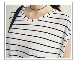 Détail d'un collier ras du cou en cuir noir minimaliste porté avec un t-shirt rayé