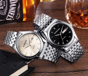 Gros plan de montres couple avec chiffres romains sur un bureau en bois sombre chic