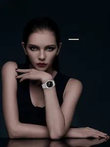 Femme élégante portant une montre en acier argenté avec cadran noir et chiffres romains