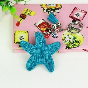 Detailed close-up of blue starfish keychain with rhinestones and leather tassel