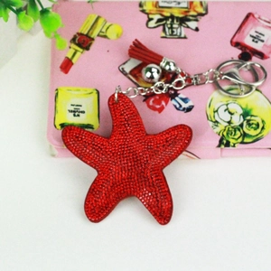 Detail of red rhinestone starfish keychain with stylish tassel and silver ring