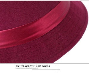 Détail du chapeau en laine bordeaux montrant les coutures fines et la texture feutrée douce