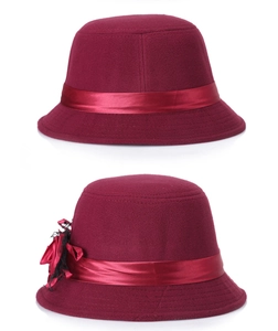 Gros plan sur un chapeau cloche en laine bordeaux avec fleur en satin et dentelle
