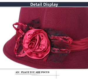 Détail d'un chapeau cloche en laine bordeaux avec rose en satin et voile en résille à pois