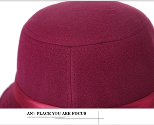Vue macro détaillée de la texture du chapeau en feutre de laine bordeaux et du ruban en satin