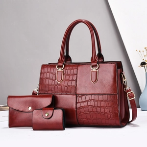Three-piece burgundy tote set featuring embossed crocodile texture and gold hardware detail
