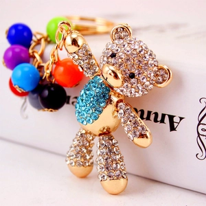Golden bear keychain with blue and white crystals and colorful beads accessory