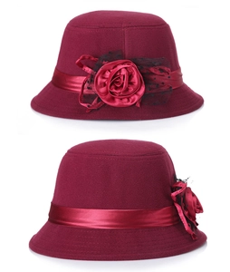 Détail d'un chapeau cloche en feutre de laine bordeaux avec grande fleur et résille noire