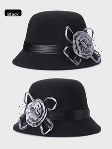 Détail d'un chapeau cloche en feutre de laine noir avec fleur en satin et voile résille