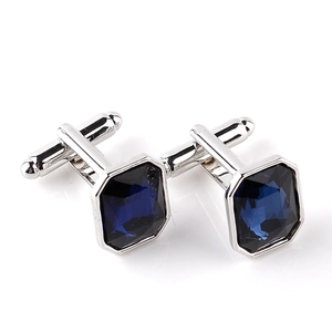 Macro shot of silver cufflinks featuring emerald-cut deep blue glass gemstones