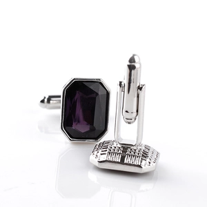 Detailed macro view of silver rectangle cufflinks with faceted deep purple crystal stones