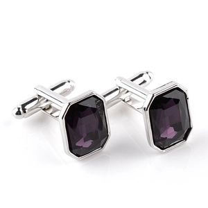 Detail shot of silver cufflinks with deep purple octagon-cut crystals on a white background