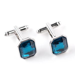 Close-up of men's French cufflinks with deep blue rectangular crystals and silver base