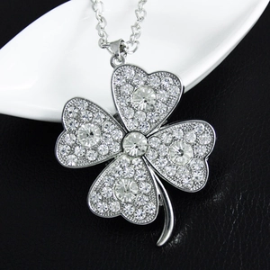 Macro shot of silver four-leaf clover necklace with sparkling white pavé crystals