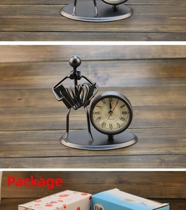 Vintage iron desk clock with accordion musician figure and packaging box detail.