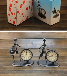Retro iron musician desk clocks shown with their decorative gift boxes on wooden background