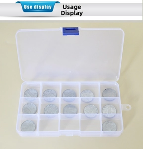 Clear 15-compartment storage box detail showing inner grid size with a coin reference