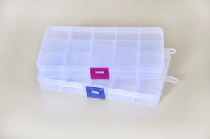 Detail view of 10-grid clear plastic storage boxes with pink and blue snap locks