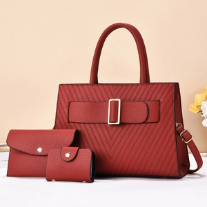 Detail von weinrotem 3-teiligem Taschenset mit V-Steppung und goldenen Metallschnallen